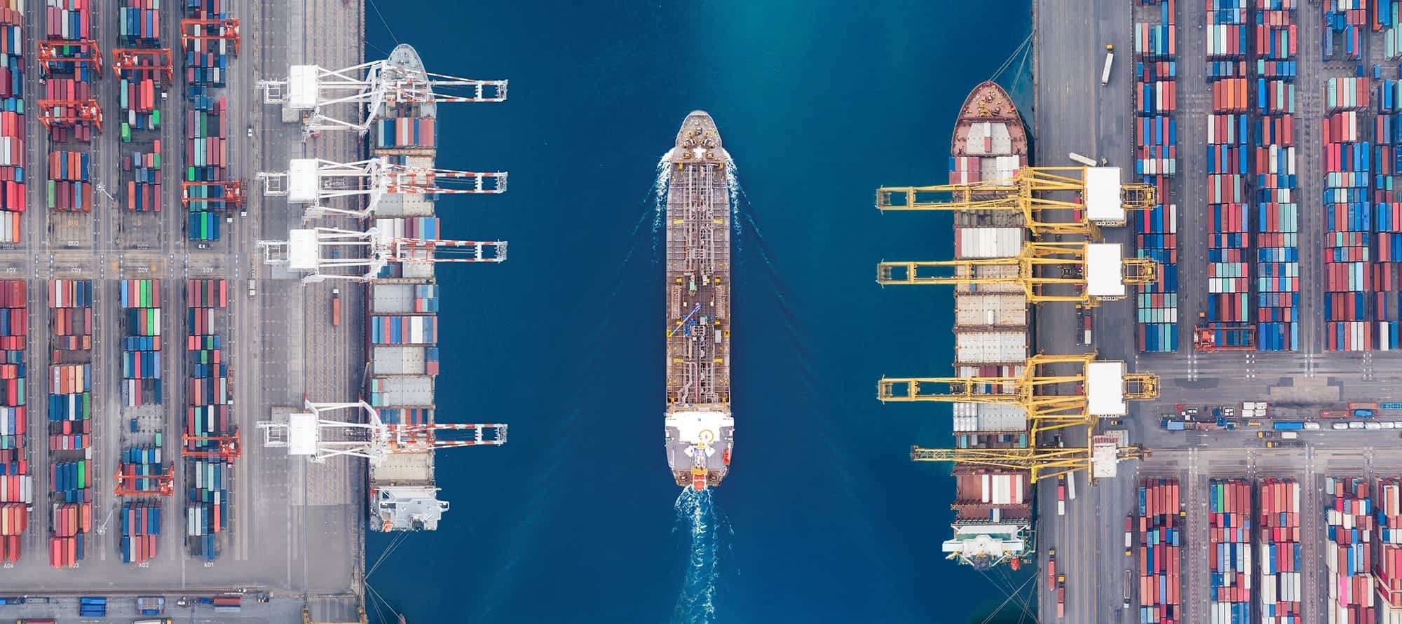 Vehicles staged in rows on a marine terminal apron awaiting loading